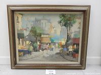 Frontal view of the framed oil on canvas painting showing entire street scene composition in wood frame