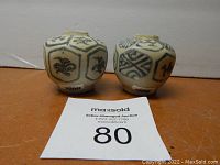 Frontal view of two blue and white globular jars with MaxSold lot card