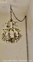 Swag lamp hanging from ceiling affixed by chain