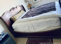 Side and angled view showing the headboard, footboard, and wood grain of the king size sleigh bed.