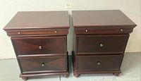 Front view of both tables side by side showing mahogany finish, dentil molding and bun feet