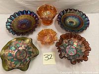 Six carnival glass pieces arranged on white backdrop