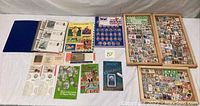 Overview of the US coins collection in blue binder, US paper money booklets, and various ephemera on a white surface