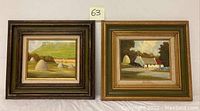 Two framed oil paintings depicting farm and countryside scenes with haystacks and buildings, both signed by Val M. Eann.