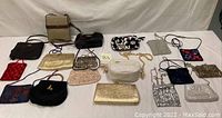 Full collection of 15 assorted women's handbags and purses laid flat for overview