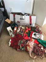 Overview shot of the lot showing artificial tree parts, tree skirt, stockings, beads, and assorted ornaments and linens.