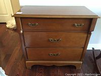Front view of the three-drawer wooden Gibbard dresser on wood flooring.