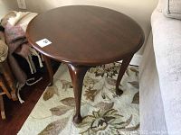 Front view of round side table showing cabriole legs and overall shape