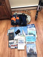 Overview of full lot including books, bags, instrument, PFD, stemware, and cups