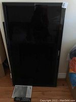 Full view of Samsung 46 inch LED TV with Sanus VisionMount, standing upright, showing screen and frame.