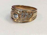 Ring front view with bezel-set center diamond and curved diamond-accented rails