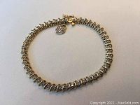 Full view of gold diamond tennis bracelet laid flat