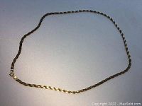 Full view of the 10K yellow gold chain laid flat on a white surface