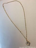 Full length view of gold Singapore chain with heart pendant on white background