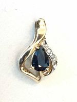 Front view of pendant on white background showing sapphire and diamond setting.