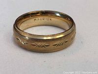 Front view of gold band showing diamond cut accents and florentine finish