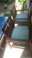 Two wooden outdoor chairs with slatted backs and light blue seat cushions, showing front and top views.