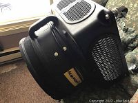 Black advertising blower machine with handle and mesh vents, showing general condition and posing for size reference.