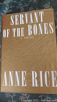 Front cover of Anne Rice's "Servant of the Bones" first edition showing dust jacket with embossed artwork and large white text.