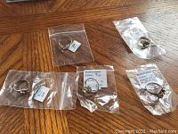 Photo showing all five rings individually bagged on a wooden table.