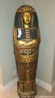 Front view of full cabinet showing sarcophagus shape and painted decorations