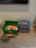Full lot overview showing green bin with wooden track pieces, plastic tunnel, support and two LEGO tubs