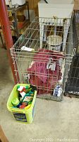 Wire metal pet crate shown with red fabric inside, in basement setting.