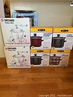 Two Tatung TAC-6G Automatic Steamer/Rice Cooker boxes stacked on left with four Bella slow cooker boxes on right.