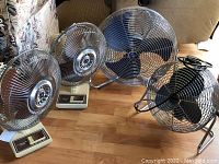 Overall view of four fans on floor showing size variations and condition