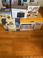 All boxed kitchen appliances including mini chopper, toaster, casserole dish, George Foreman grill, toaster oven.