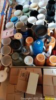 Top-down photo showing multiple coffee mugs of various types and colors packed together