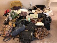 Wide view of assorted purses, handbags, and totes arranged on floor showing variety of shapes, sizes, and colors.