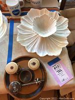 Photo showing the ceramic serving dish and bowl on top. Below is a round wooden tray holding a small dark bowl, two painted gourds, and a wooden stir spoon.