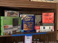 Full view of shelf showing all items including TV converter box, Kings Quest VI, VGA Games #3, and software titles with manuals.