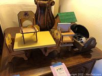 Wooden play furniture set including table, four chairs, crib, small house, and accessory