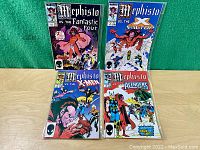 Full view of the four comics laid out, each featuring Mephisto on the cover and different Marvel superhero teams.