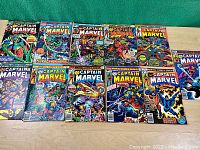 Full lot of 12 Captain Marvel comics laid out, colors vivid, covers visible.