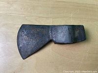 Top view of the old trade axe head showing broad blade and worn metal surface