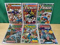 Six issues of The Avengers comics numbered 204, 205, 207, 208, 212, 228 laid out on a green surface.