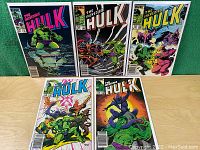 Five Marvel comic books, The Incredible Hulk Vol.1 issues 297, 302, 304, 306, 308, laid out in a row with colorful covers depicting Hulk and other characters in action scenes.