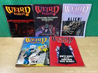 Front view photo of five Weird Worlds magazines laid out showing colorful sci-fi and horror themed covers.