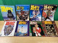 Lot of 8 vintage Heavy Metal adult science fiction comics magazines laid out on green background, various illustrated covers.