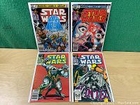 Four vintage Marvel Comics Star Wars comic books, in protective bags, displayed upright showing front covers with colorful Star Wars-themed artwork.