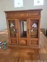 Jewelry box with decorative floral glass panels on table