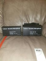 Two boxed Lafayette Dynamic Microphones Model MO-102 on a leather chair, one box partially open showing cable.