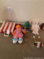 Full lot as seen with toy turntable case, Ernie doll, Winnie-the-Pooh candle lamp, Bearington bear, and TY animals on carpeted floor.