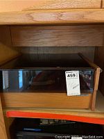 Front view of United Audio turntable with closed dark tinted lid in wooden cabinet