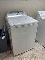 Front left angle view of washer showing overall condition and cabinet