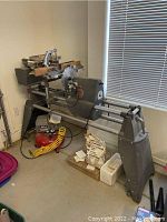 Full side view of lathe assembly with bed rails, legs and mounted circular saw blade