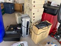 Photo of vintage tape deck, Panasonic receiver, and related cables stored in cardboard Kodak box, with additional items nearby.